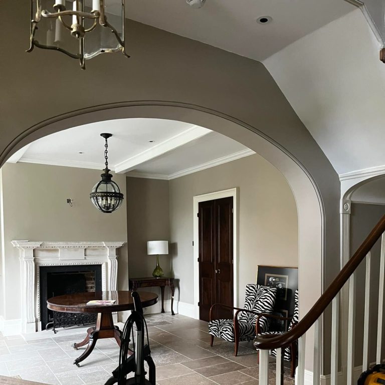 Spacious living room with a fireplace, chandelier, and elegant furniture.