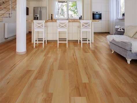 Light wooden floor with a spacious kitchen and lounge area in a bright interior.